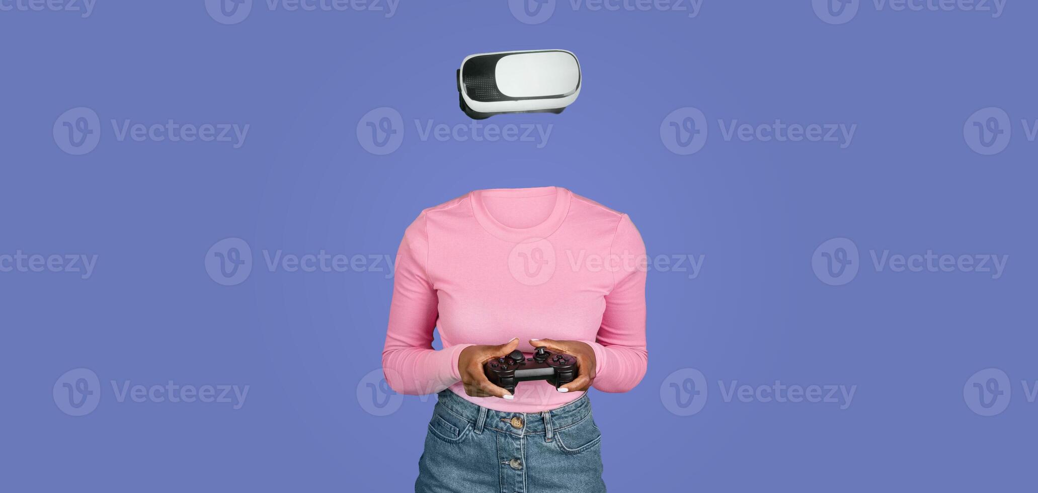 A person using virtual reality goggles plays a game, fully immersed in a digital experience. They hold a gaming controller while the background is a solid color, emphasizing the technology. photo