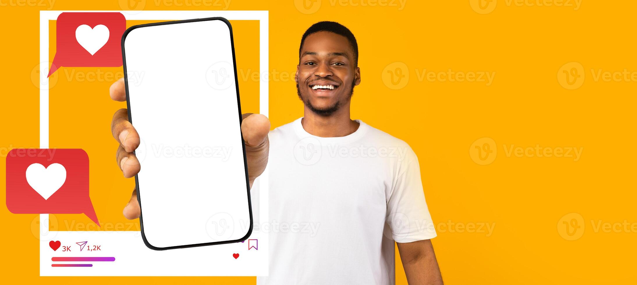 A smiling influencer holds a smartphone with a blank screen against a bright yellow background. photo