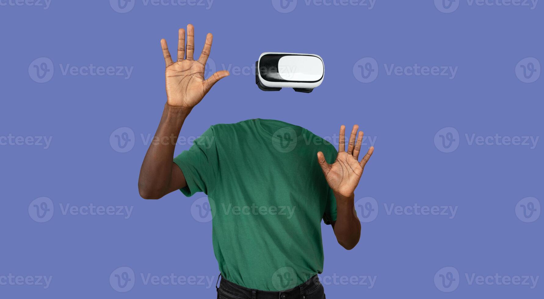 A person wearing virtual reality goggles engages with an unseen environment. Their head is not visible, creating an intriguing visual effect. Hands are raised, indicating interaction with the device. photo