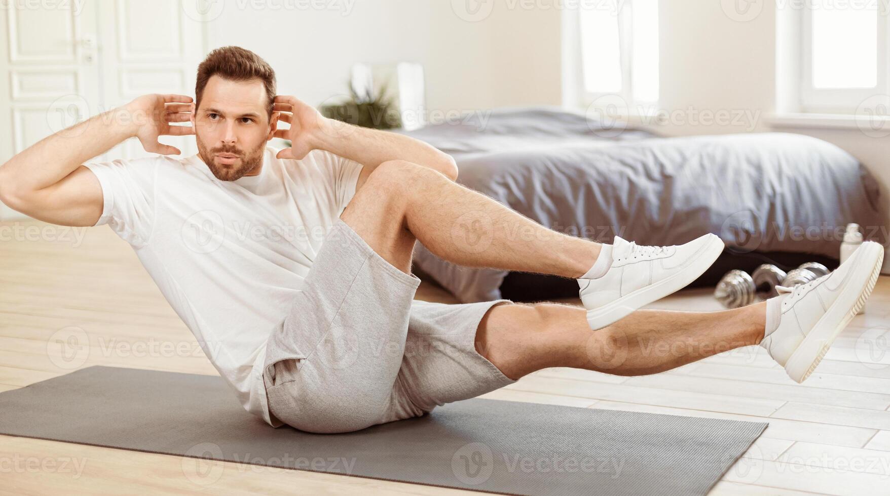 Workout. Fit Man Doing Knee-To-Elbow Crunches On Gymnastics Mat At Home In The Morning, Abs Exercises And Male Fitness Routine, Sporty Lifestyle Concept. Panorama photo
