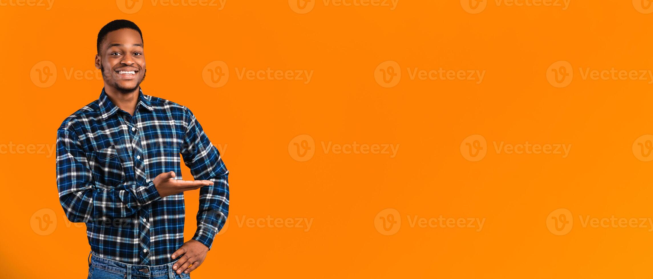 Look At This. Joyful Black Man Showing Copy Space Gesturing Aside Posing On Yellow Background In Studio photo