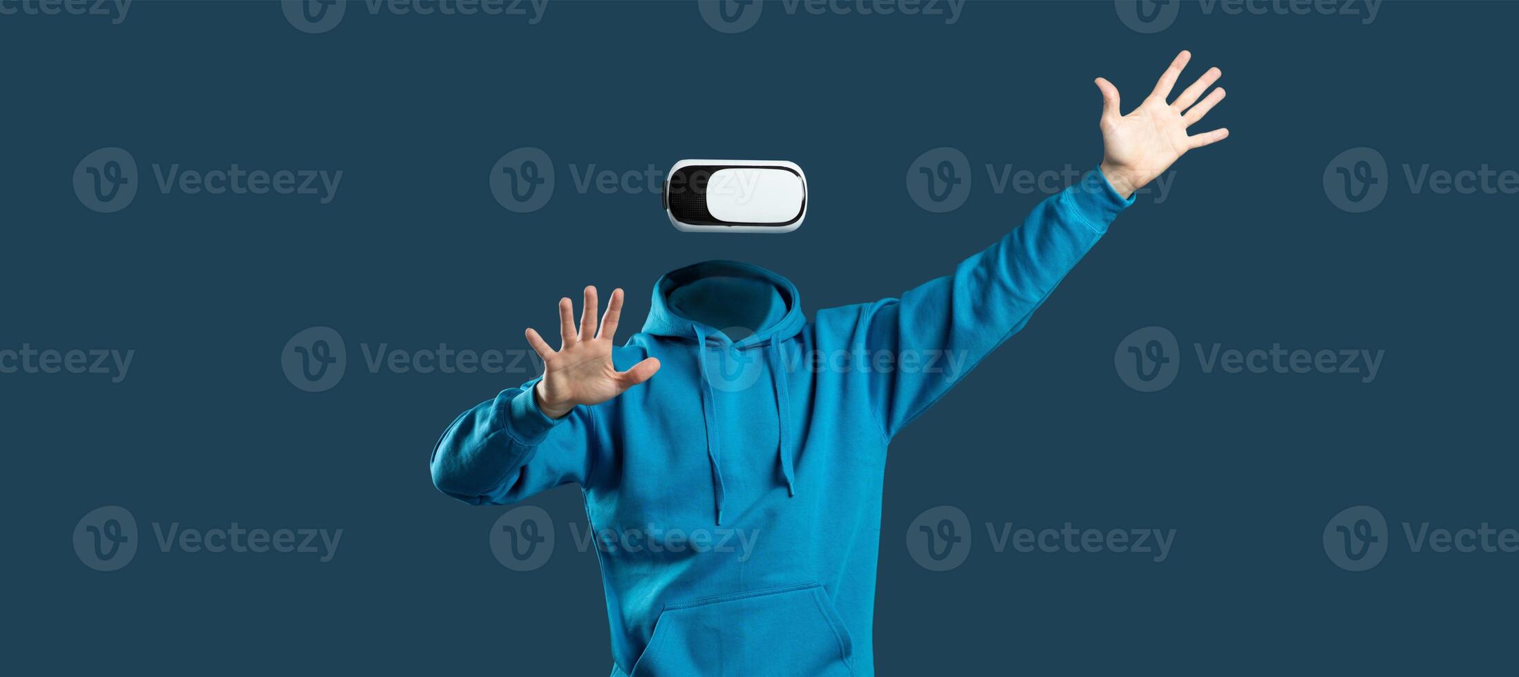 A person wearing virtual reality goggles interacts enthusiastically, with hands raised, showcasing the immersive technology. photo
