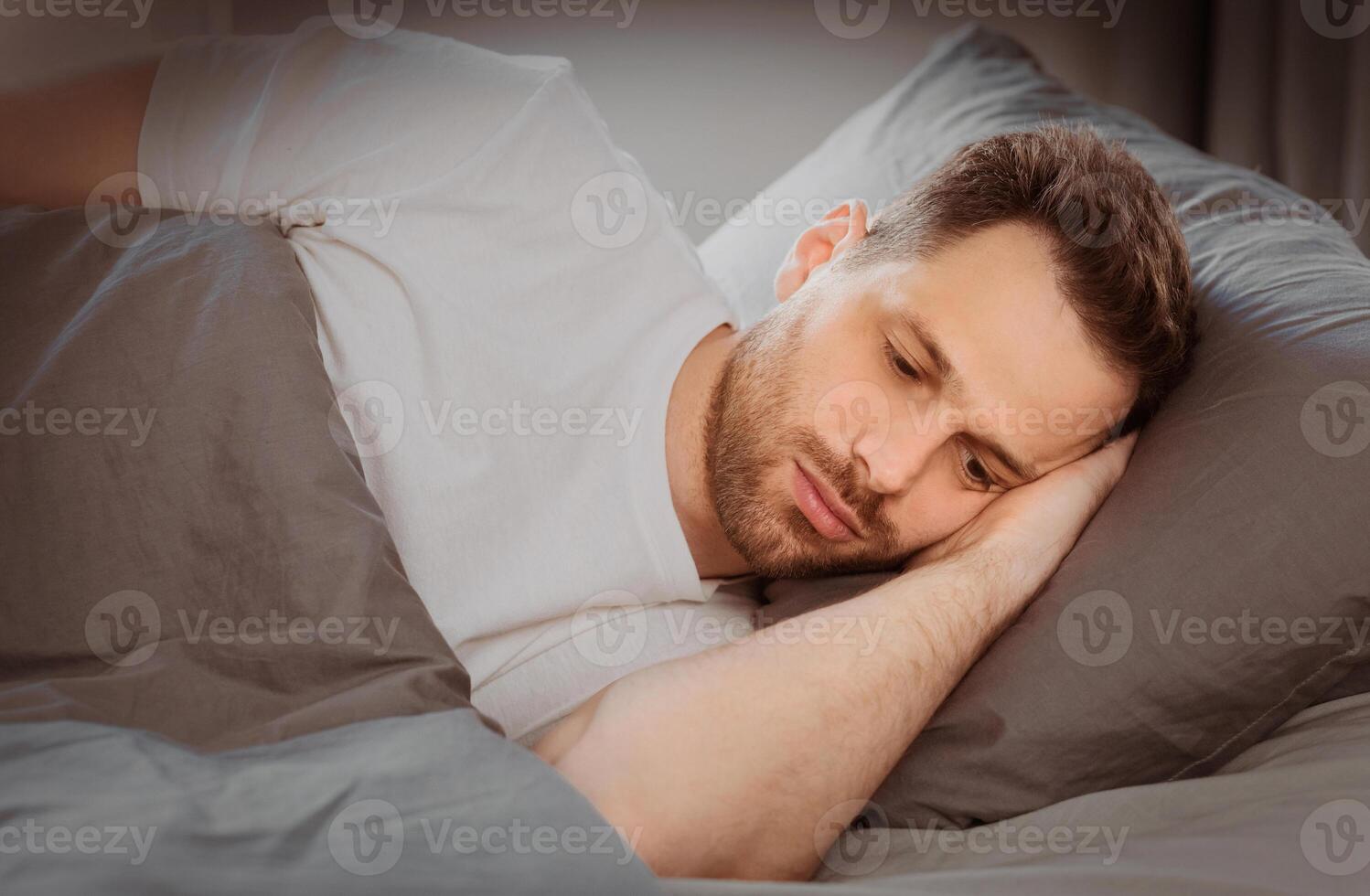 Depressed Man Having Insomnia Unable To Sleep Lying In Bed In Bedroom At Home At Night. Sleeplessness, Mental Health Problem, Male Depression Concept. Low Light photo