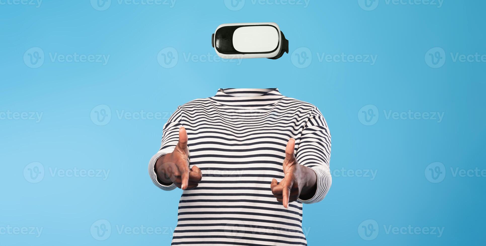 A person engages with virtual reality technology while wearing a headset. The individual has no visible facial features, emphasizing the device. The background is a solid color. photo