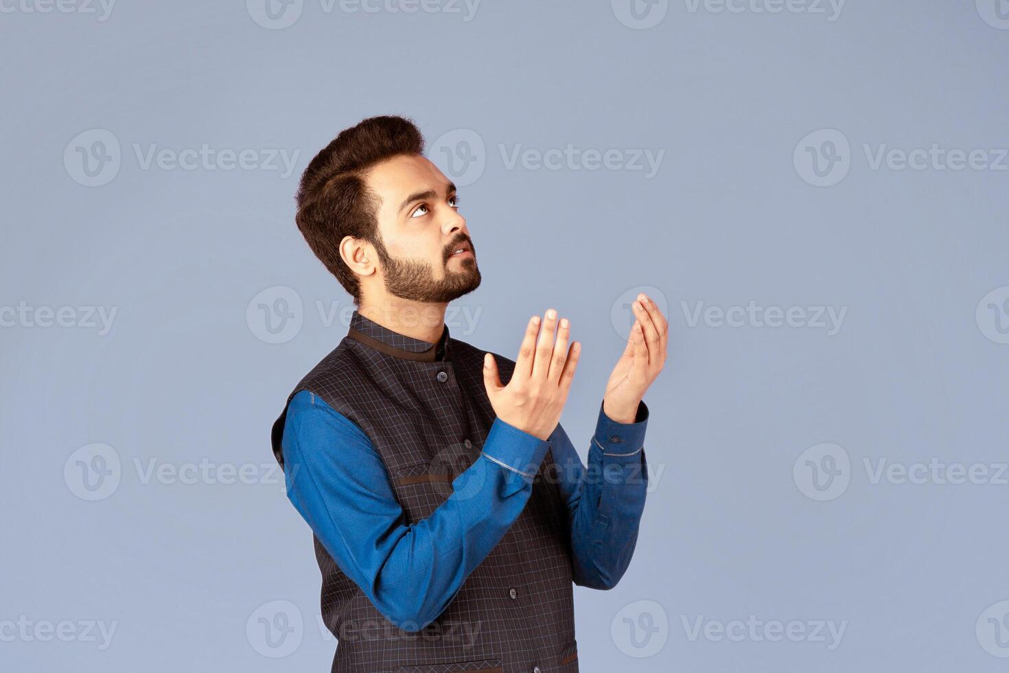 Indian man praying to God, asking for help or forgiveness on lilac background, panorama photo