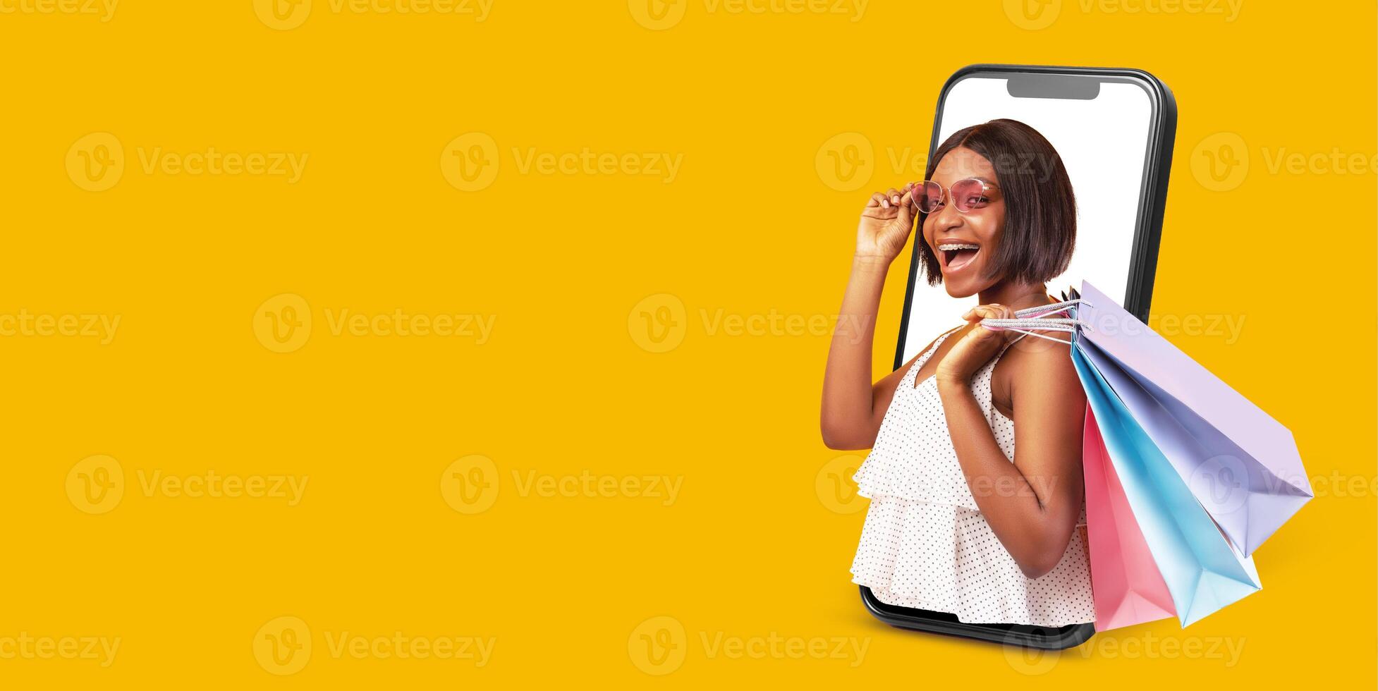 A delighted customer engages in online shopping using a smartphone. She holds shopping bags and smiles, showcasing the ease and joy of digital commerce against a bright yellow background. photo