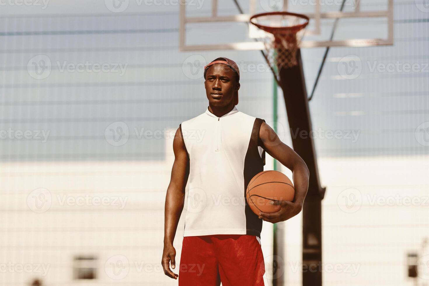Portrait of millennial African American sportsman with basketball at outdoor stadium photo
