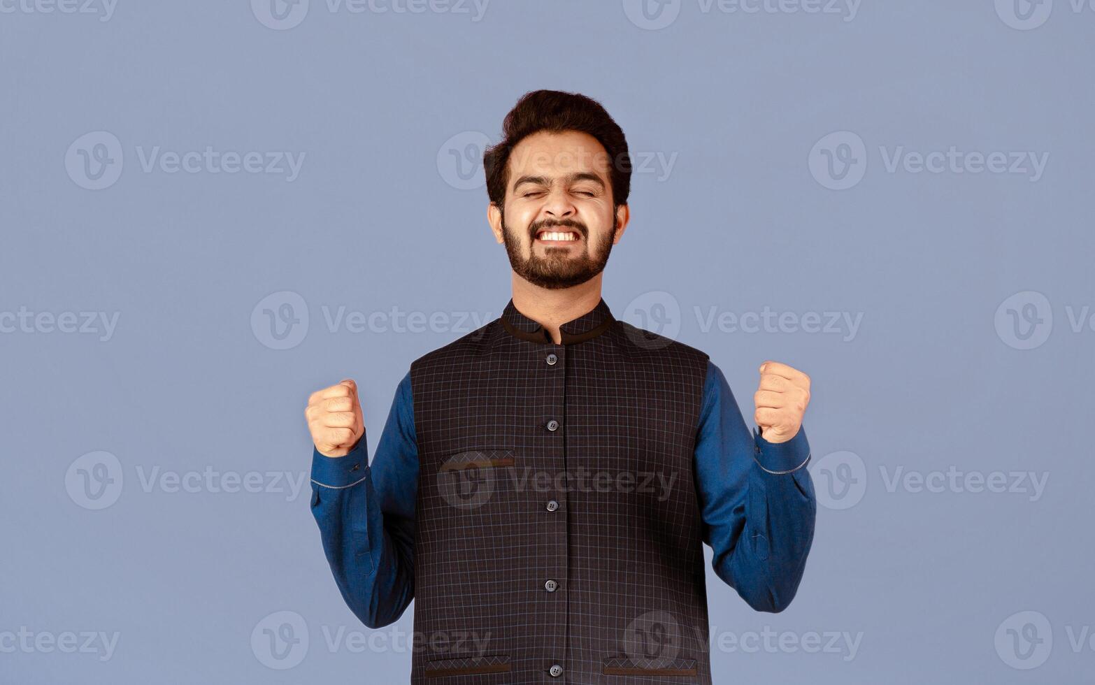 Triumphant Indian man making YES gesture, celebrating his success on violet background. Panorama photo
