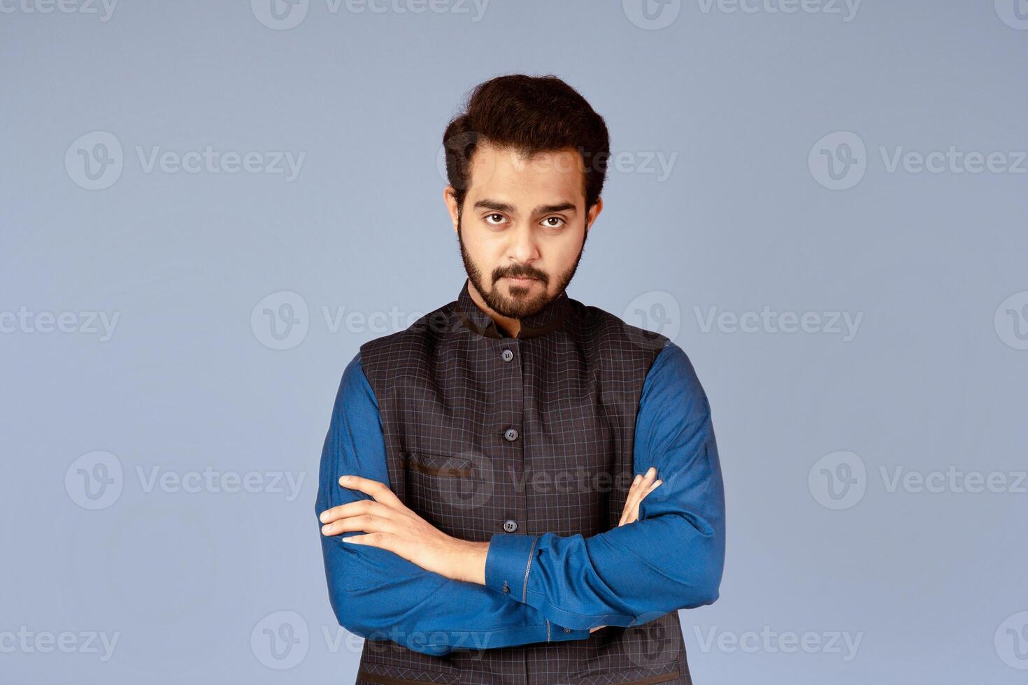 Portrait of serious Indian man with crossed arms over lilac background photo