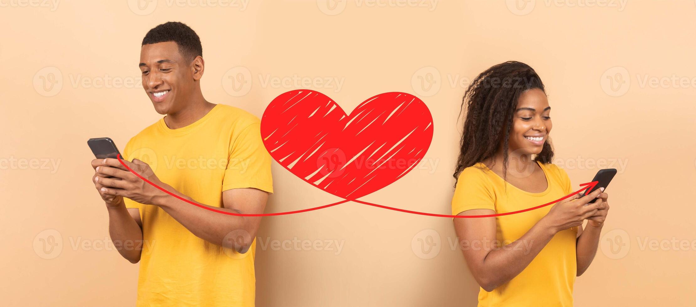 A joyful couple celebrates St. Valentines Day while using their smartphones to send affectionate messages. Their smiles and connection highlight the love shared online. photo