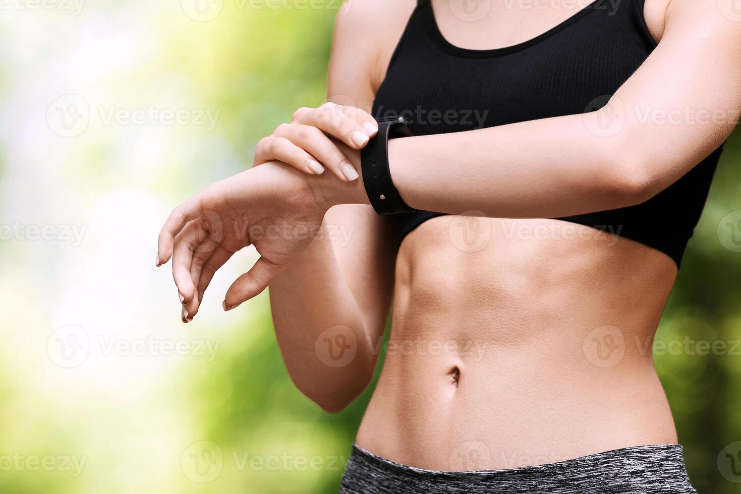 Young asian girl checking time and cardio heart rate on sport smartwatch outdoors during running in park, cropped image, panorama with copy space photo