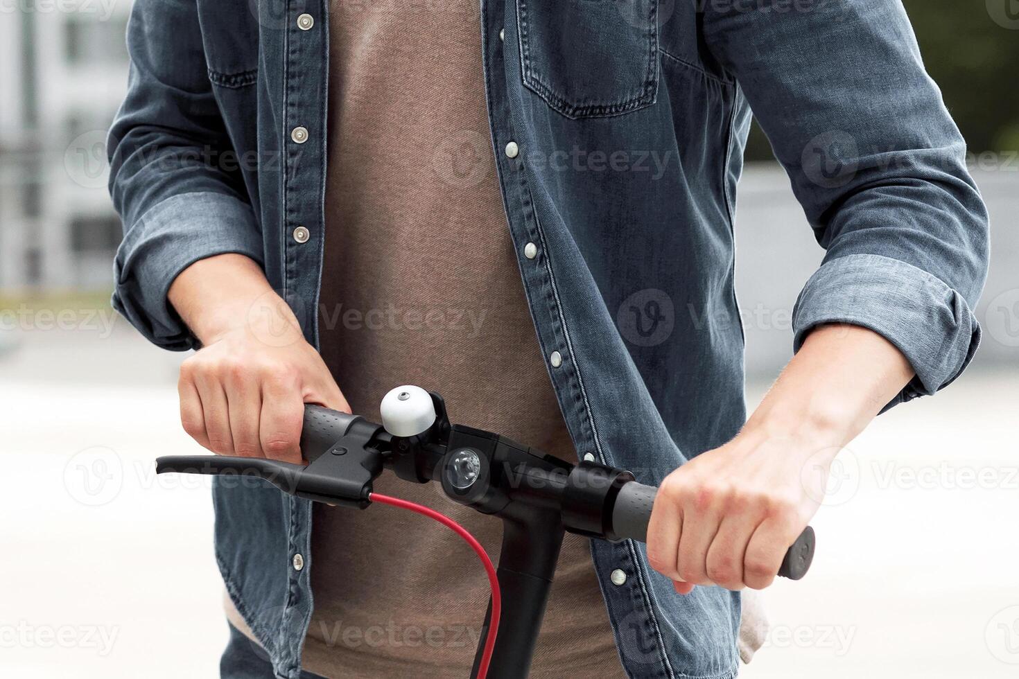 Urban Lifestyle. Cropped of guy driving motorized kick scooter in the city background photo