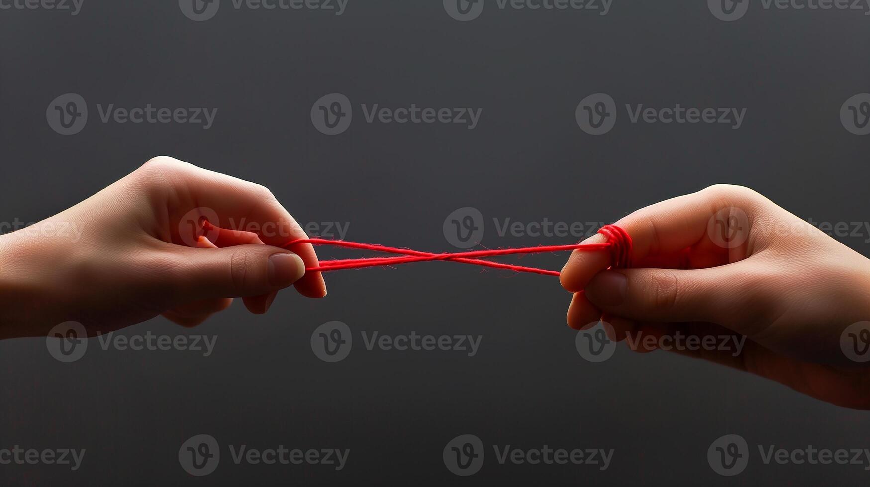 This Two hands grasp a red string, illustrating tension and the potential for reconciliation. photo