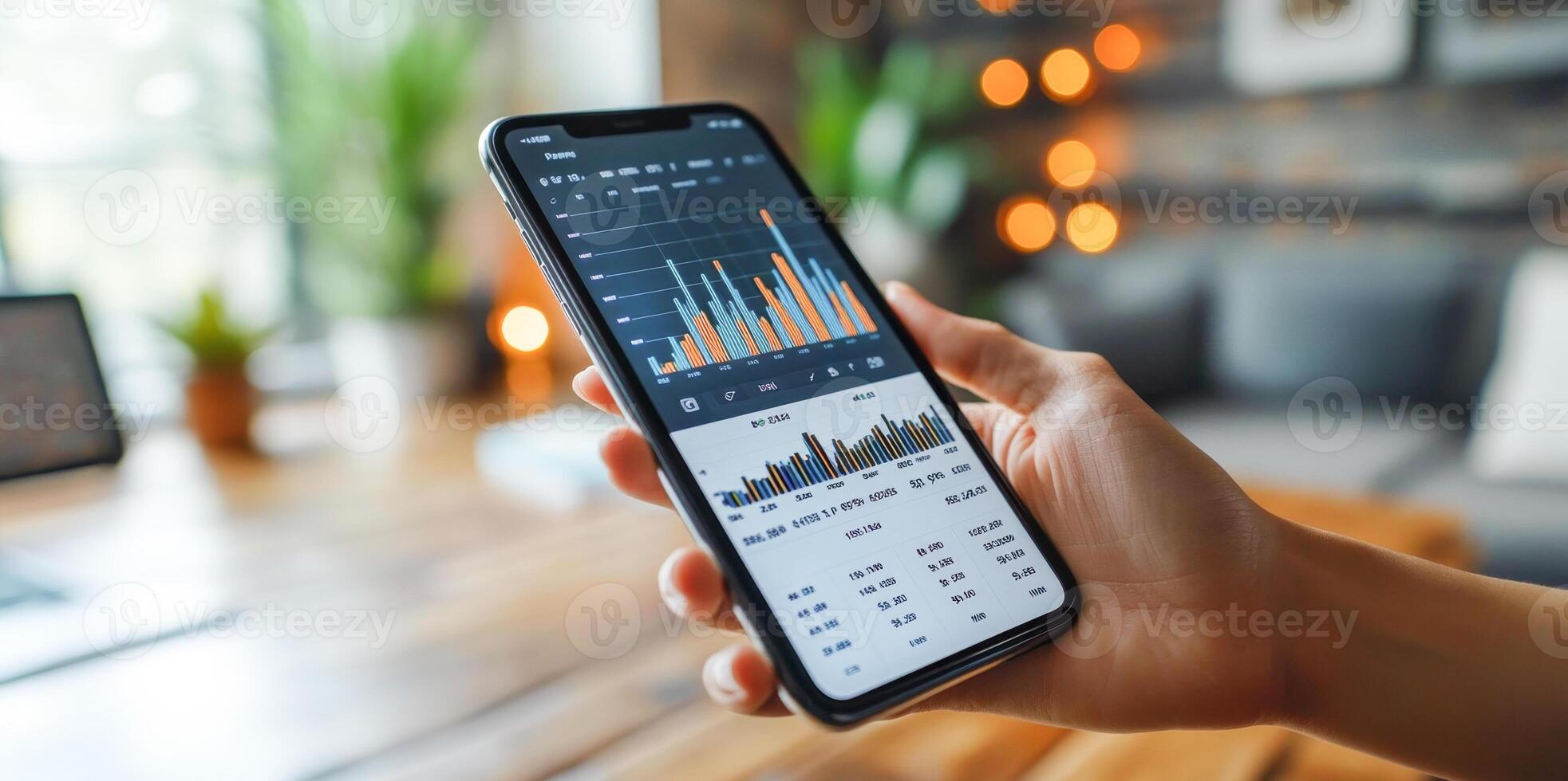 A person holds a smartphone displaying a detailed banking application with transaction statistics and financial statements. photo