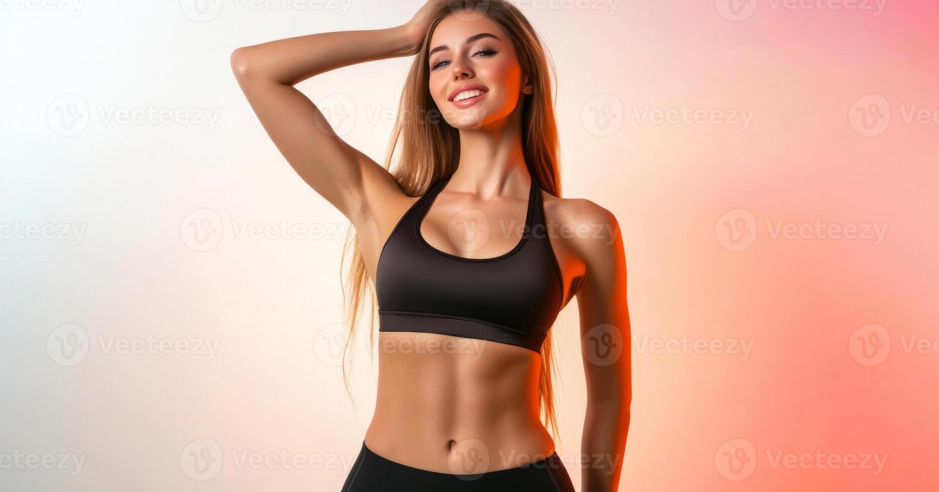A fashionable woman poses confidently in a black athletic ensemble against a soft pastel backdrop. She has long hair and is enjoying a moment of self-expression while showcasing her active lifestyle. photo
