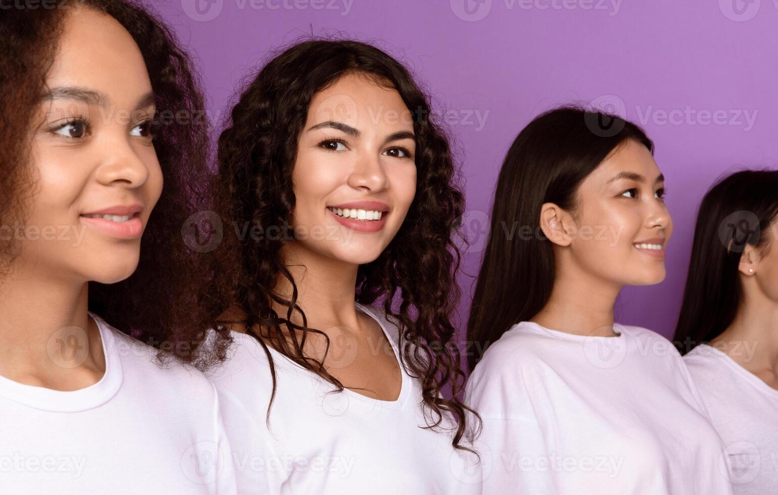 Latin Woman Smiling To Camera Standing In A Row With Group Of Happy Multiracial Young Ladies Posing Together On Purple Background. Studio Shot. Female Diversity And Unity Concept photo