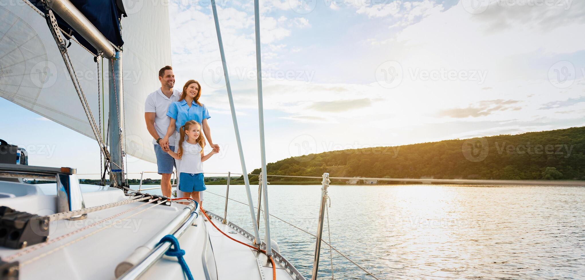 Joyful Family Standing On Sailboat Deck Enjoying Yacht Ride On Beautiful Summer Day Having Vacation At Seaside. Parents And Daughter Spending Weekend Sailing Outdoors. Panorama, Free Space photo