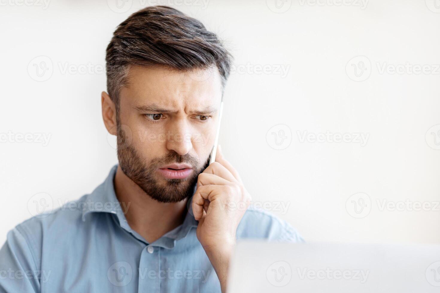 Computer Problem. Concerned Millennial Businessman Talking On Cellphone With Customer Support, Having Troubles With Laptop Or Internet Connection At Workplace In Office, Suffering System Error photo