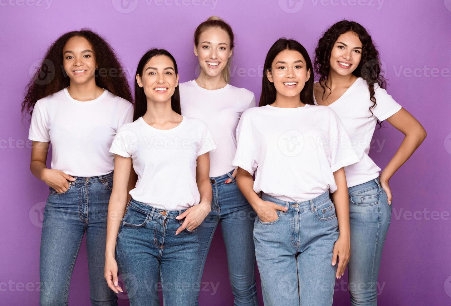 Group Of Happy Mixed Women Posing Hugging Together Standing Over Purple Background, Smiling To Camera. Female Unity, Friendship And Diversity Concept. Studio Shot photo