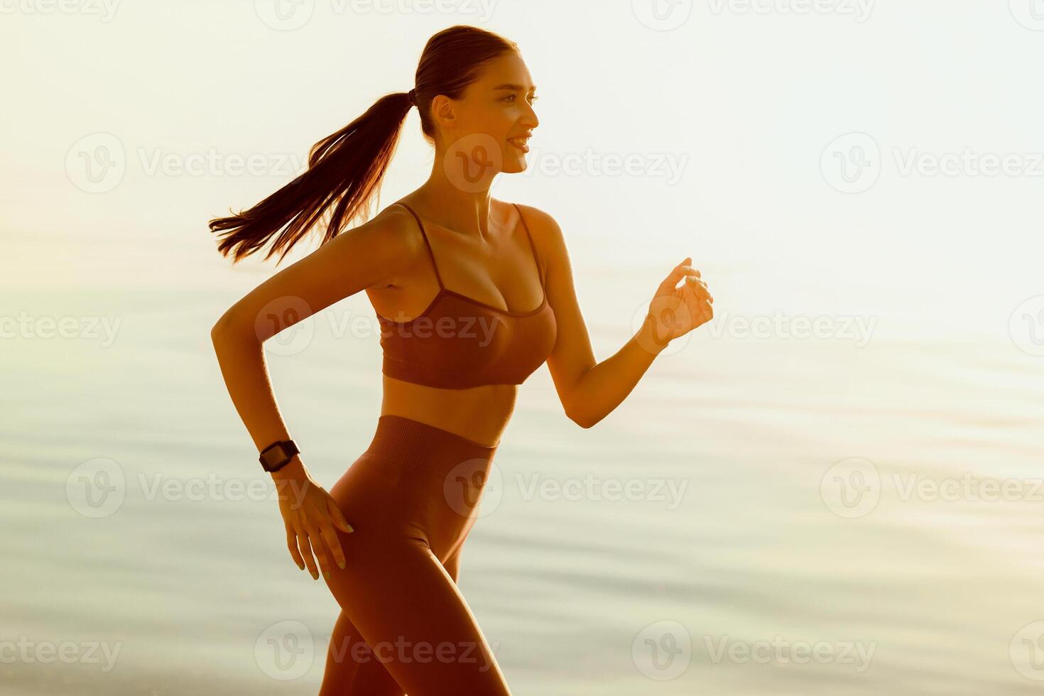Endurance. Side view portrait of beautiful lady in sportswear running at the seaside in the daylight, free space photo