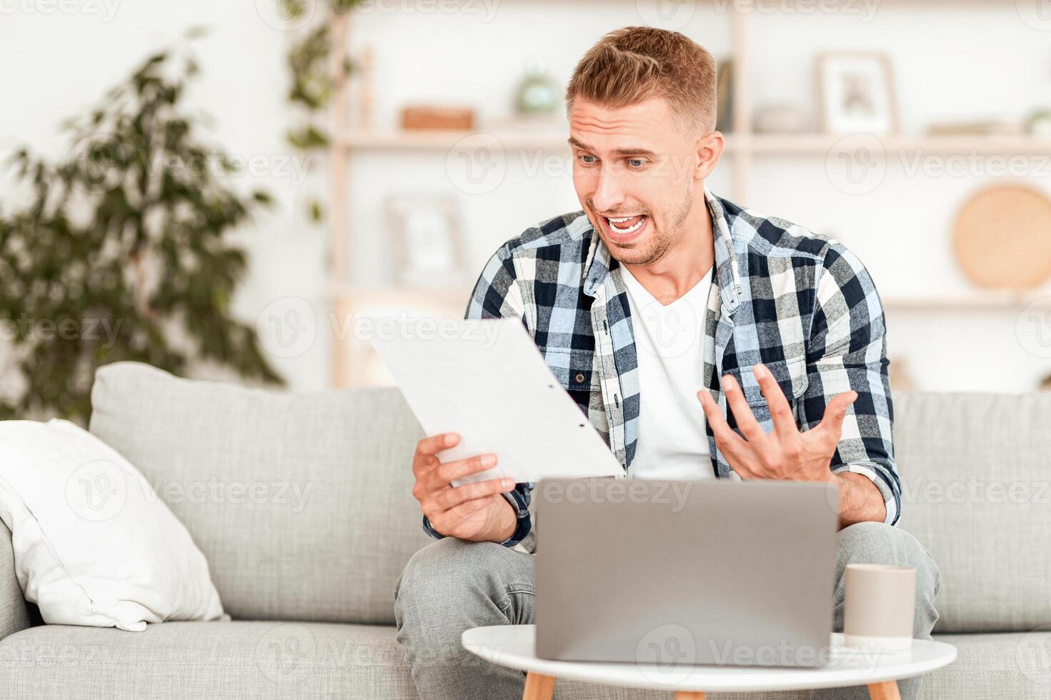 Bad News And Money Problem. Man Screaming And Gesturing While Reading Mail Letter Or Debt Notification photo