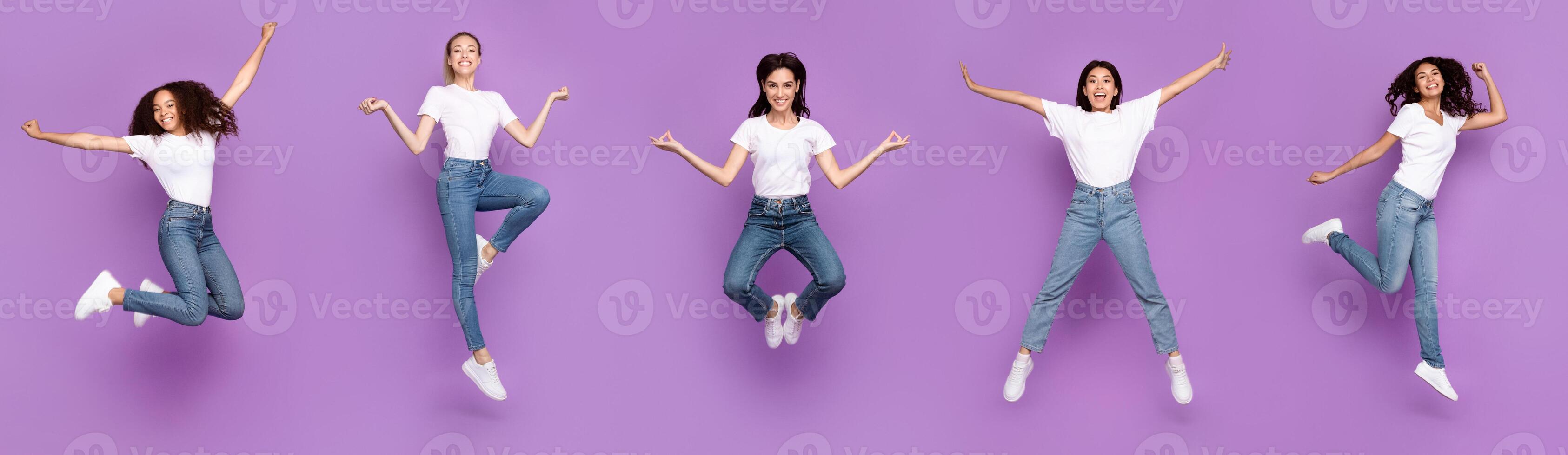 Five Multiracial Women Jumping Posing In Mid-Air Having Fun Over Purple Background, Smiling To Camera. Different Poses Jump Concept. Panorama, Studio Shot, Full Length photo