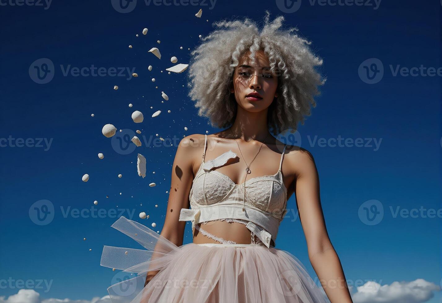 A woman with an afro and a tulle skirt is standing on a beach photo
