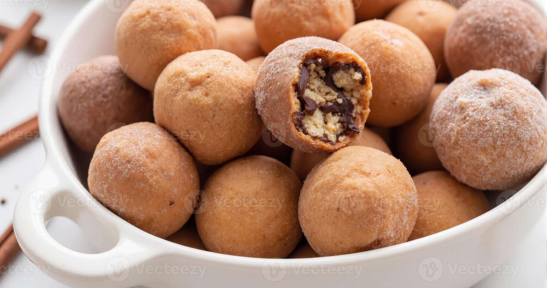 A bowl filled with doughnuts and cinnamon sticks photo