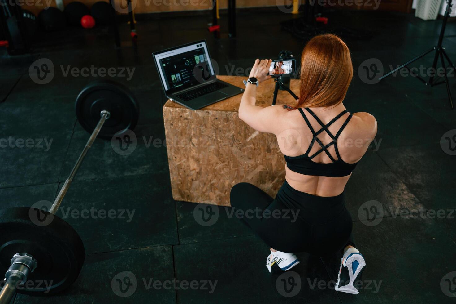 View from the back. Shooting by smartphone. Beautiful ,strong woman is in the gym photo