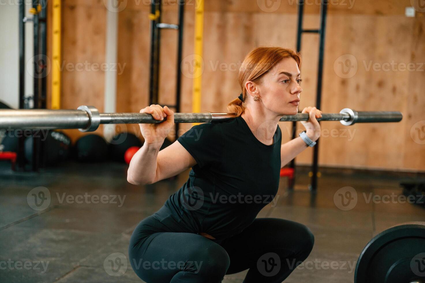 Lifting the barbell. Beautiful strong woman is in the gym photo