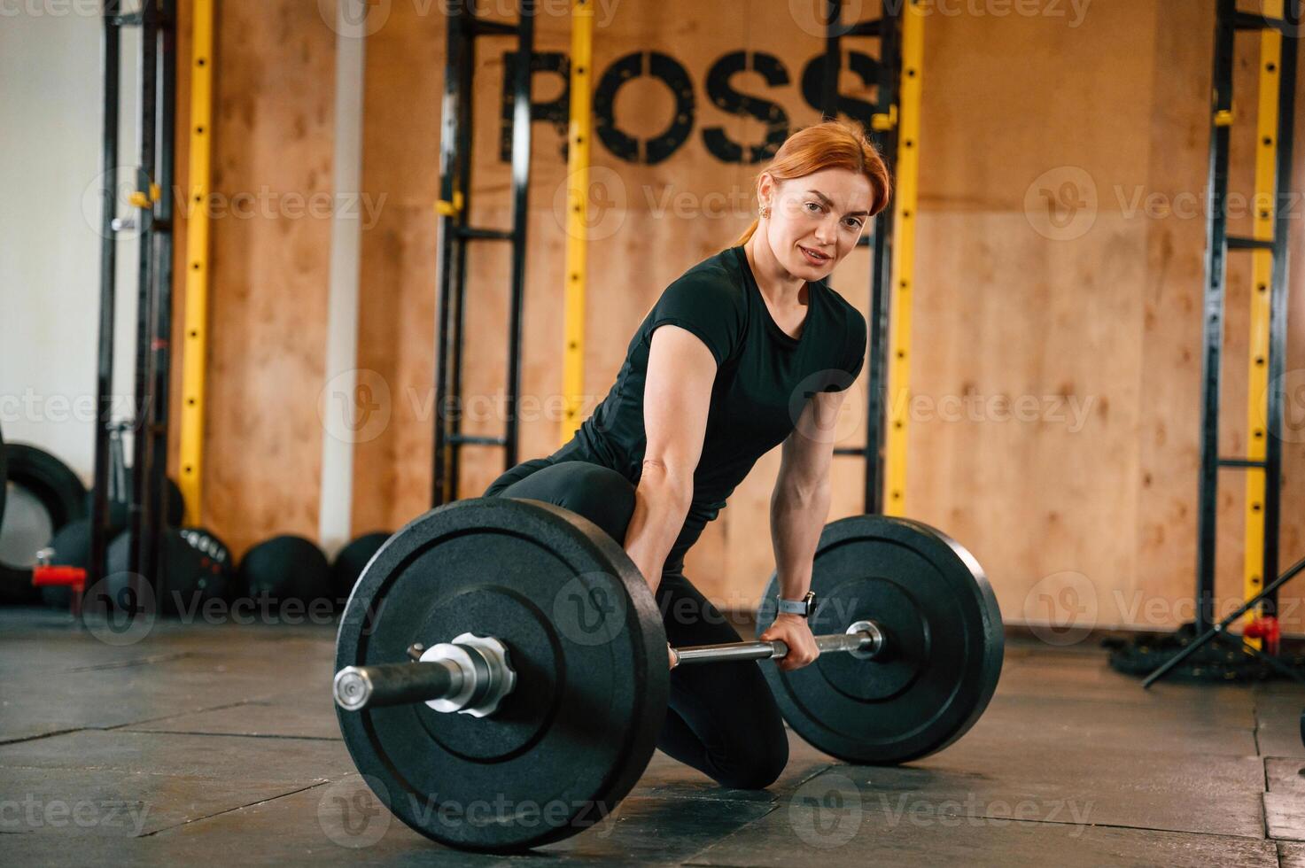 Leaning ,on the ,barbell. On the floor. Beautiful strong woman is in the gym photo