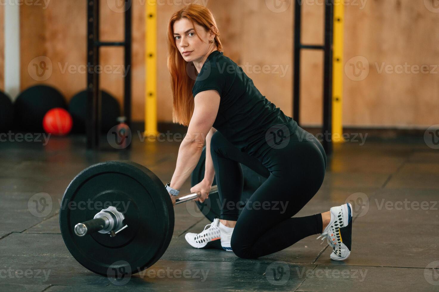 Sitting, with, barbell on the floor. Beautiful strong woman is in the gym photo