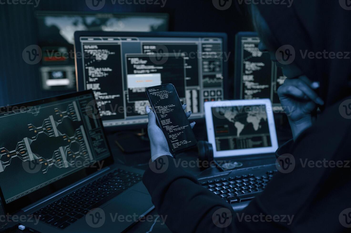 Holding, smartphone with code. Young professional female hacker is indoors by computer with lot of information on displays photo