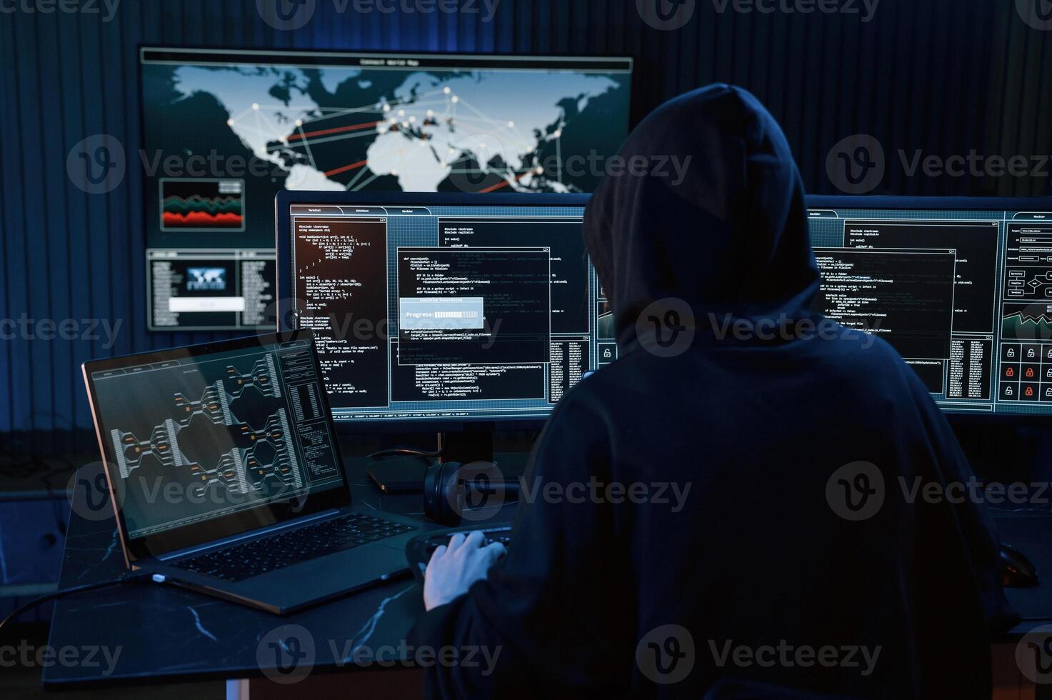 Dark, room. Young professional female hacker is indoors by computer with lot of information on displays photo