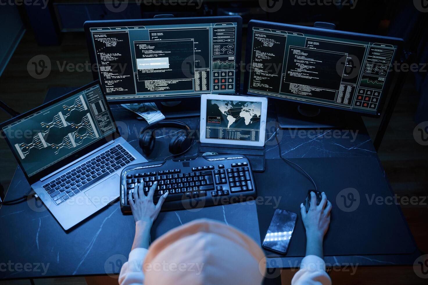 Phishing attack. Young professional ,female ,hacker is indoors by computer with lot of information on displays photo