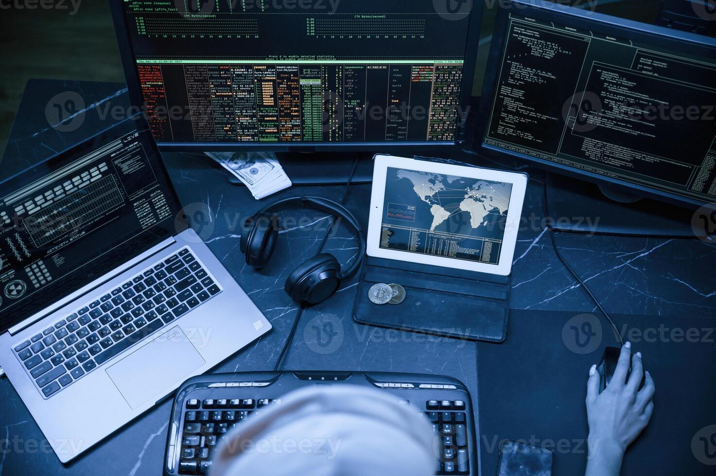 Top view.. Young, professional female hacker is indoors by computer with lot of information on displays photo