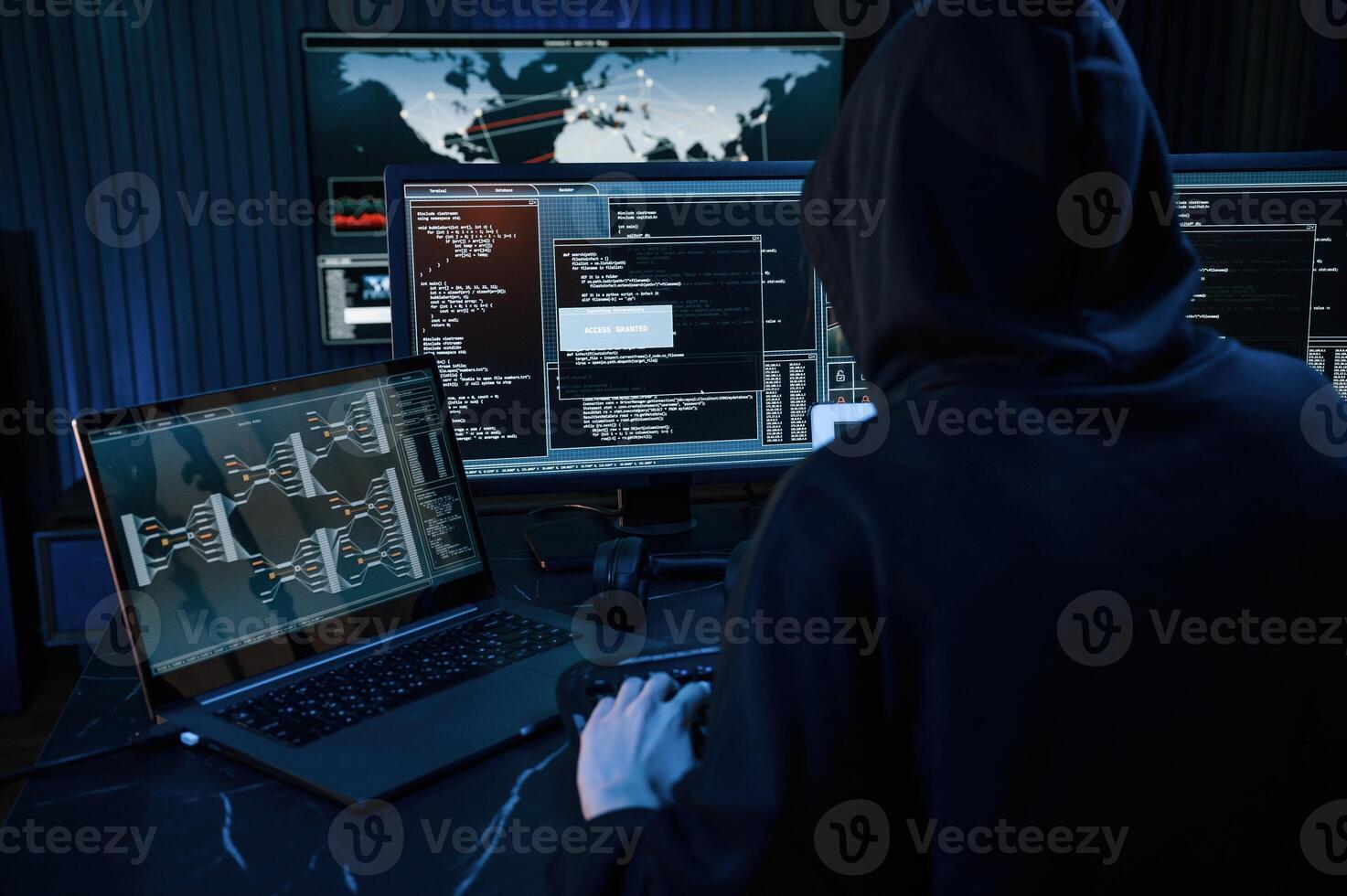 Dark room. Young professional female hacker is indoors by computer with lot of information on displays photo
