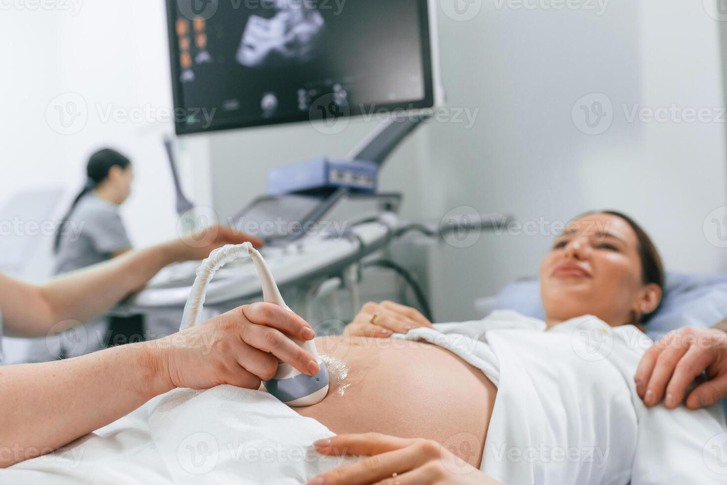 Smiling, medical ,procedure... Pregnant woman is lying down in the hospital, doctor does ultrasound photo
