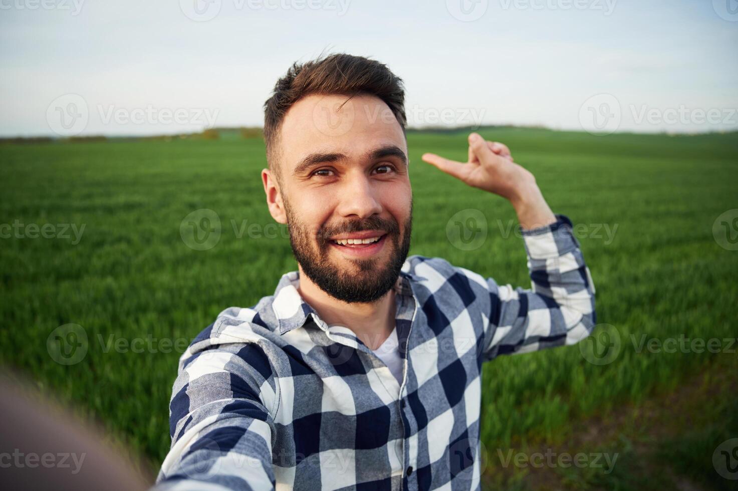 Making ,selfie. Handsome young man, is, on agricultural field photo