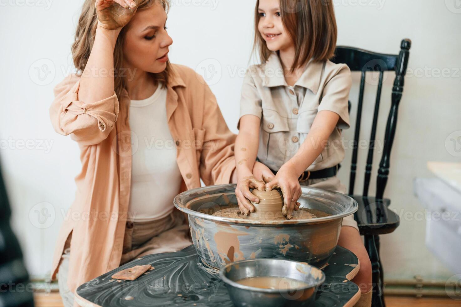 Creating ,the, pot. Mother ,with little girl doing pottery at home photo