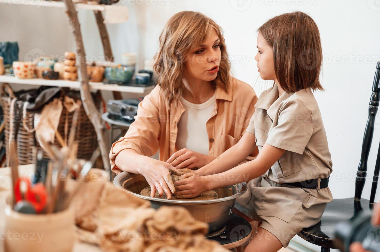 Clay modeling. Mother with, little girl doing pottery at home photo