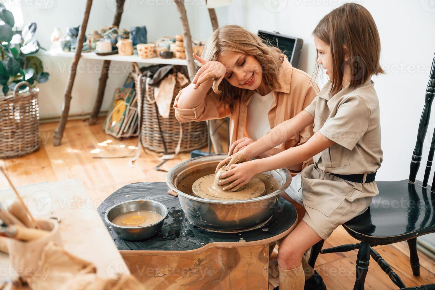 Clay, modeling,. Mother with little girl doing pottery at home photo