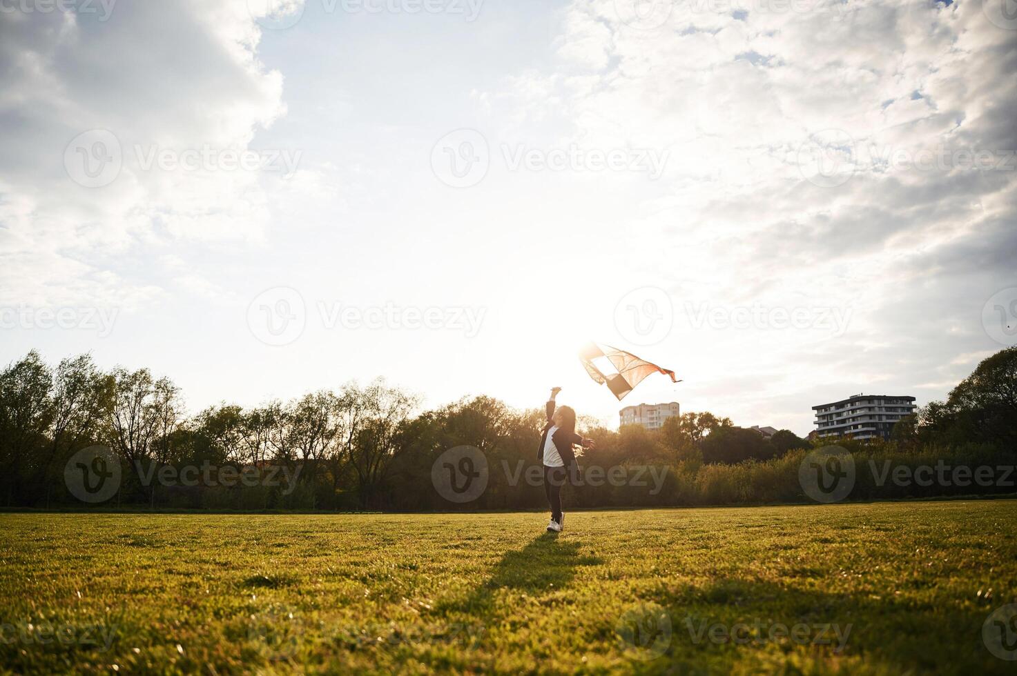 Beautiful,, sunlight. Happy little girl is playing with kite on the summer field photo