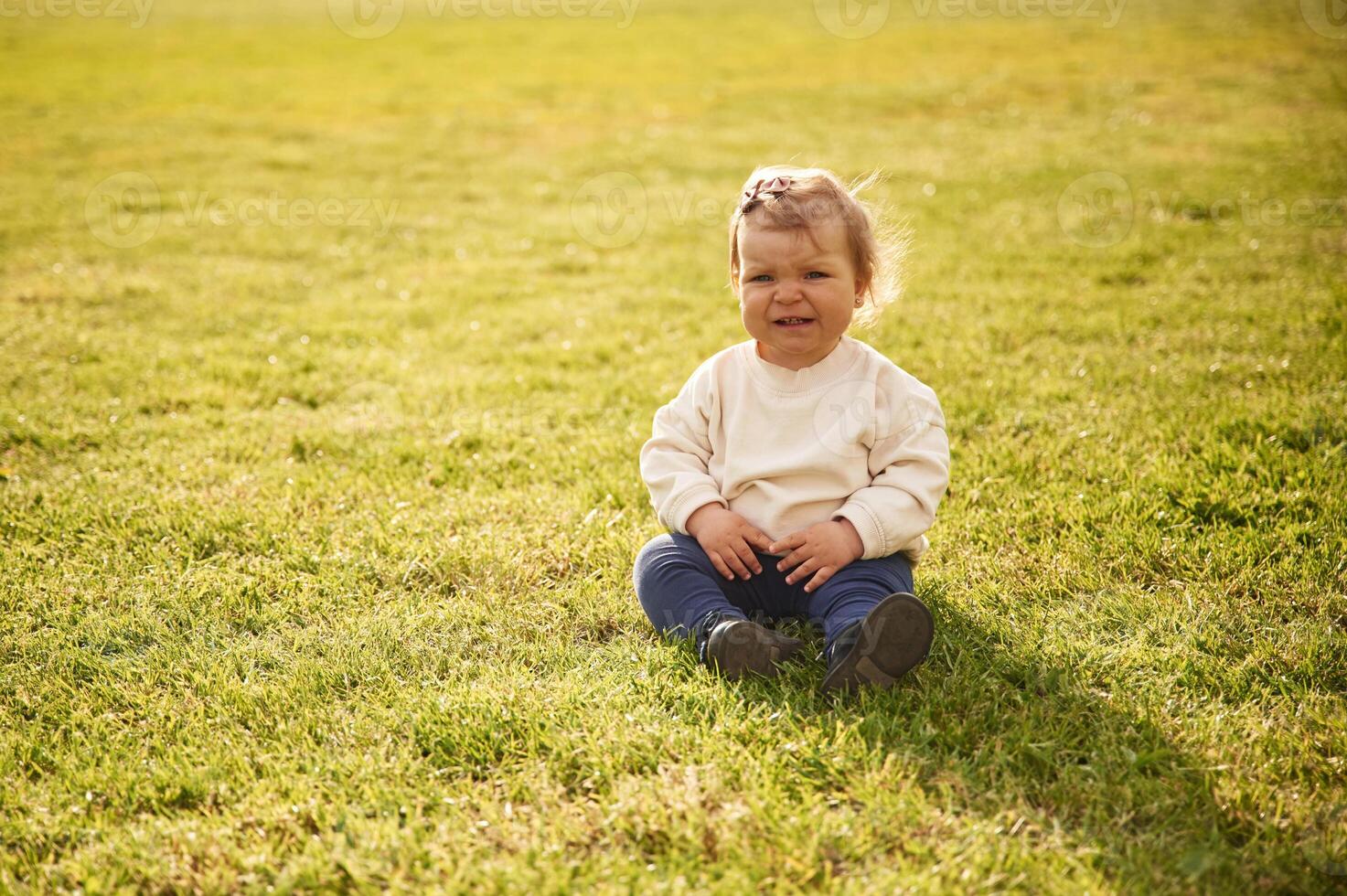 Little, girl, in casual clothes is on the summer field photo