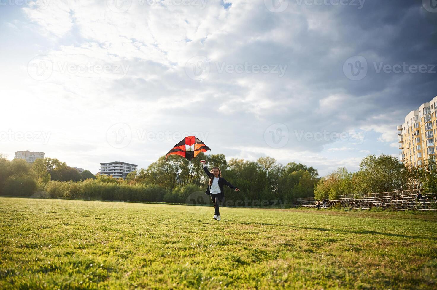 Happy little girl is playing ,with kite on the summer field photo