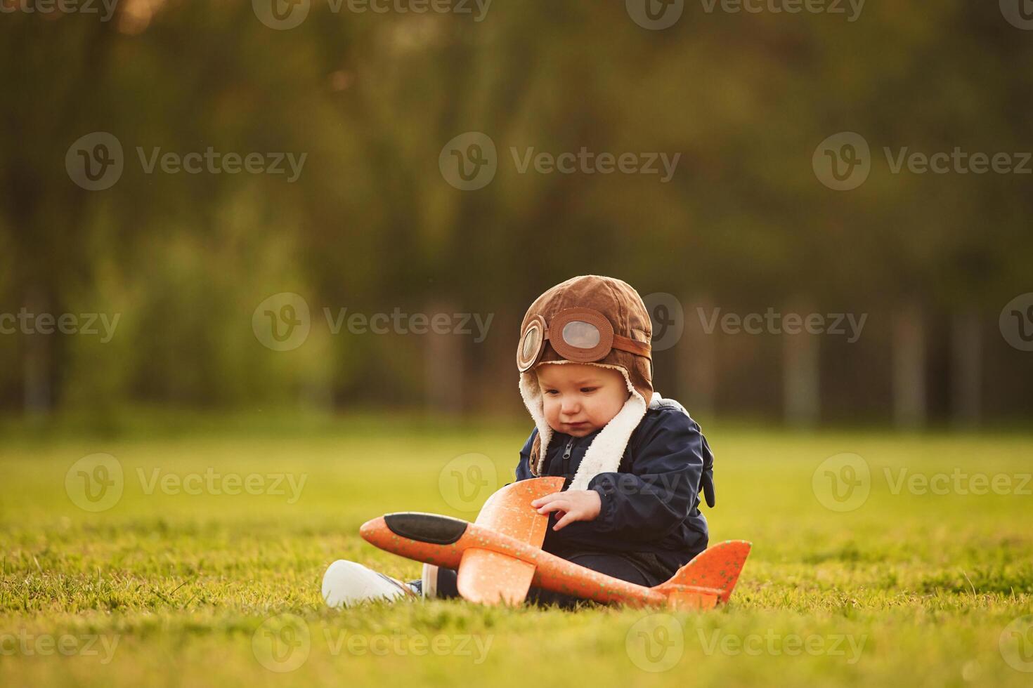 Focused ,view with ,,background. Little boy is playing with toy plane on the summer field photo