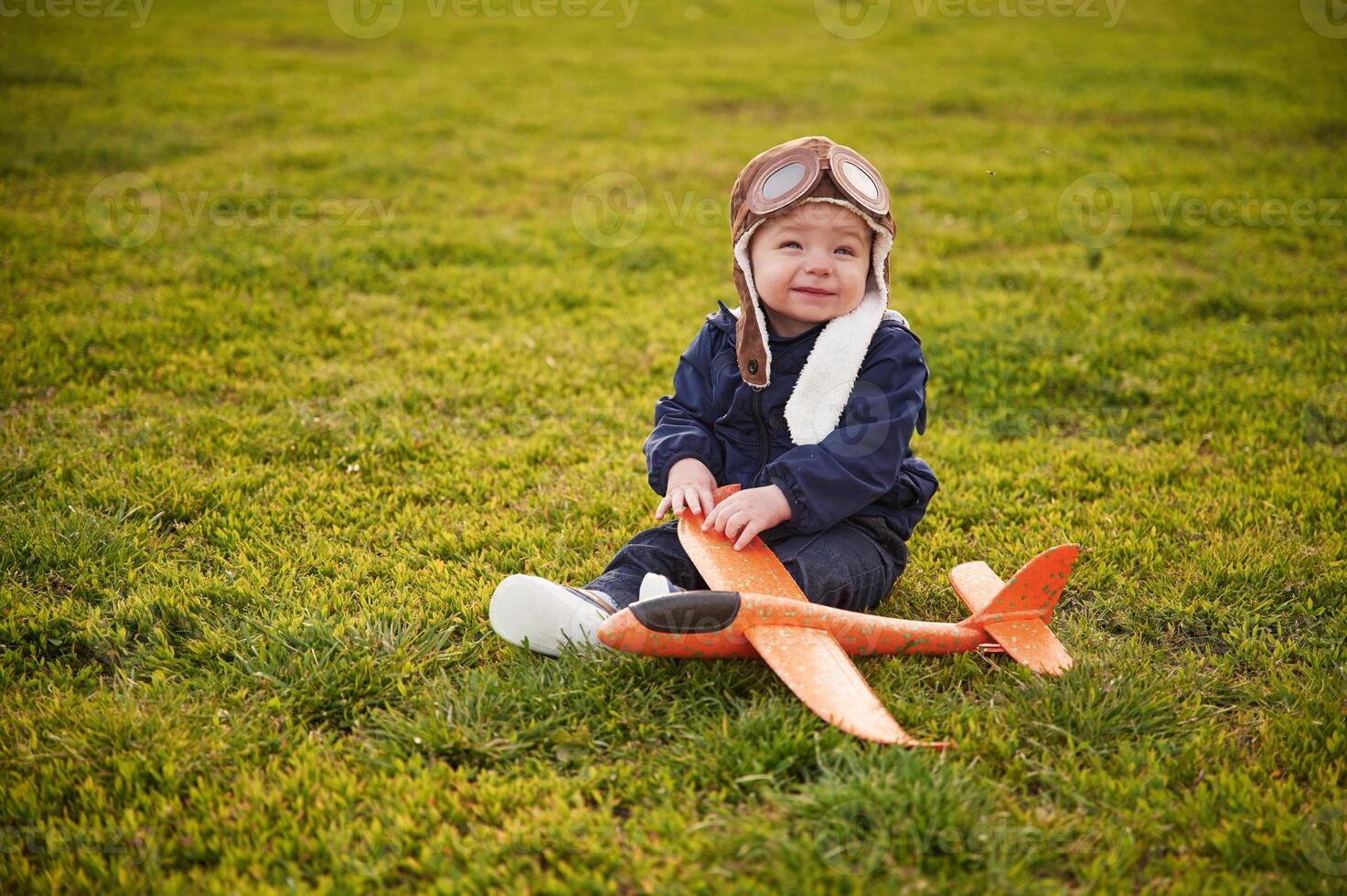 Little boy, is with toy plane on the summer field photo
