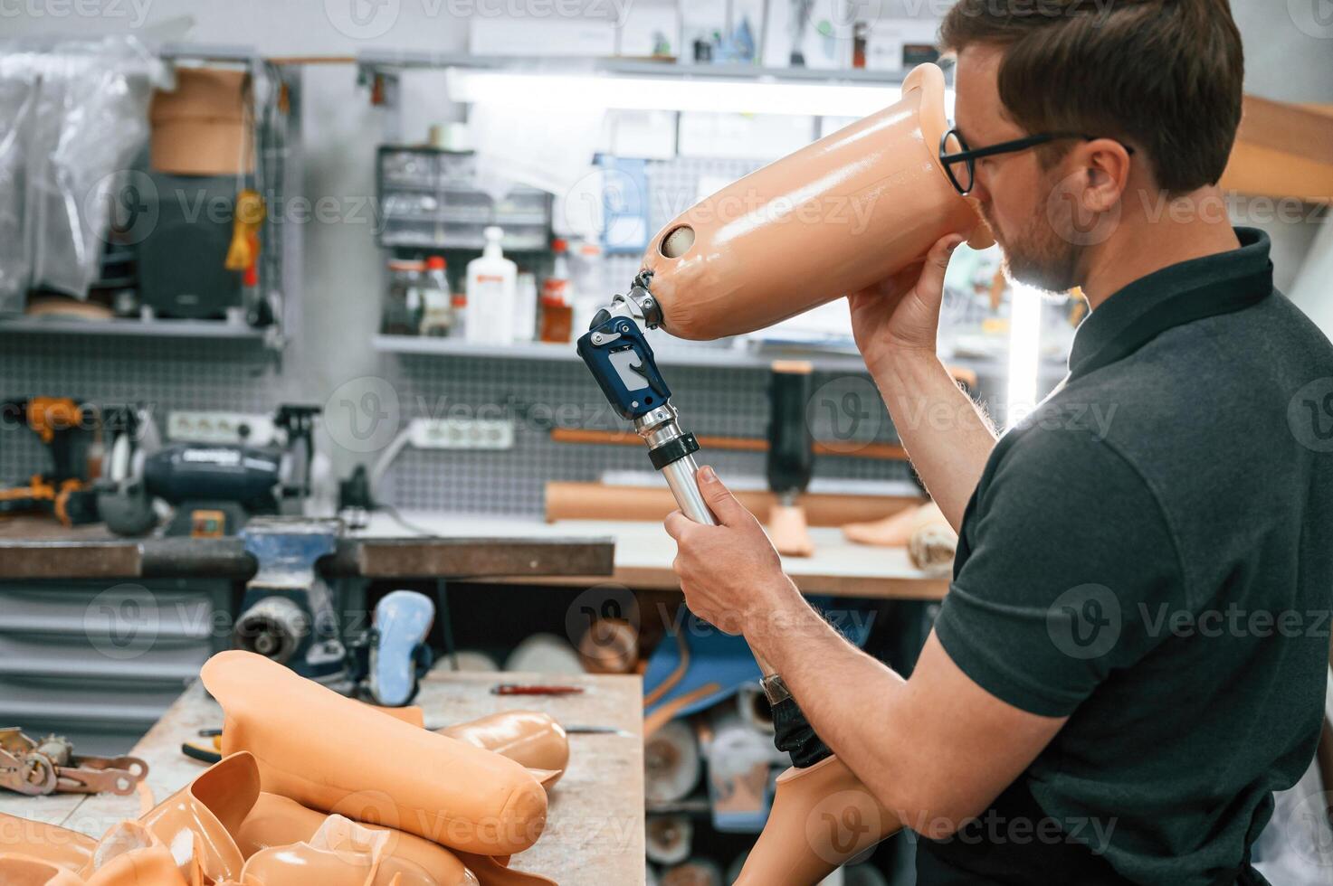 Checking the ,movement ability ,of product. Technician working with prosthesis in modern laboratory photo