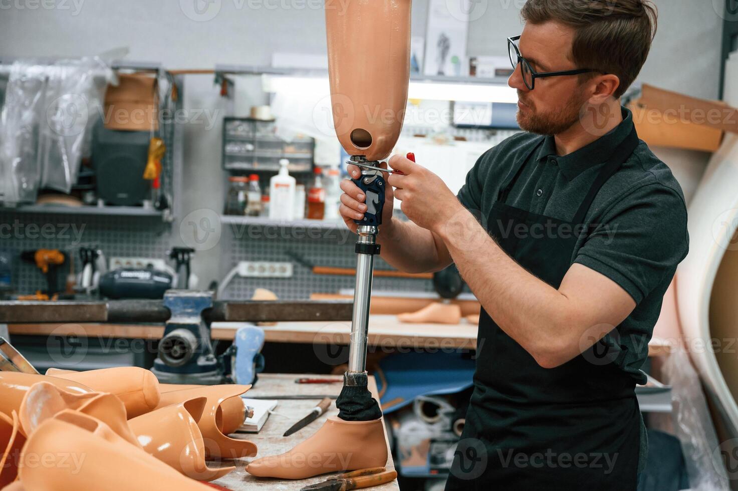 With prosthesis ,in hands. Technician working with prosthesis in modern laboratory photo