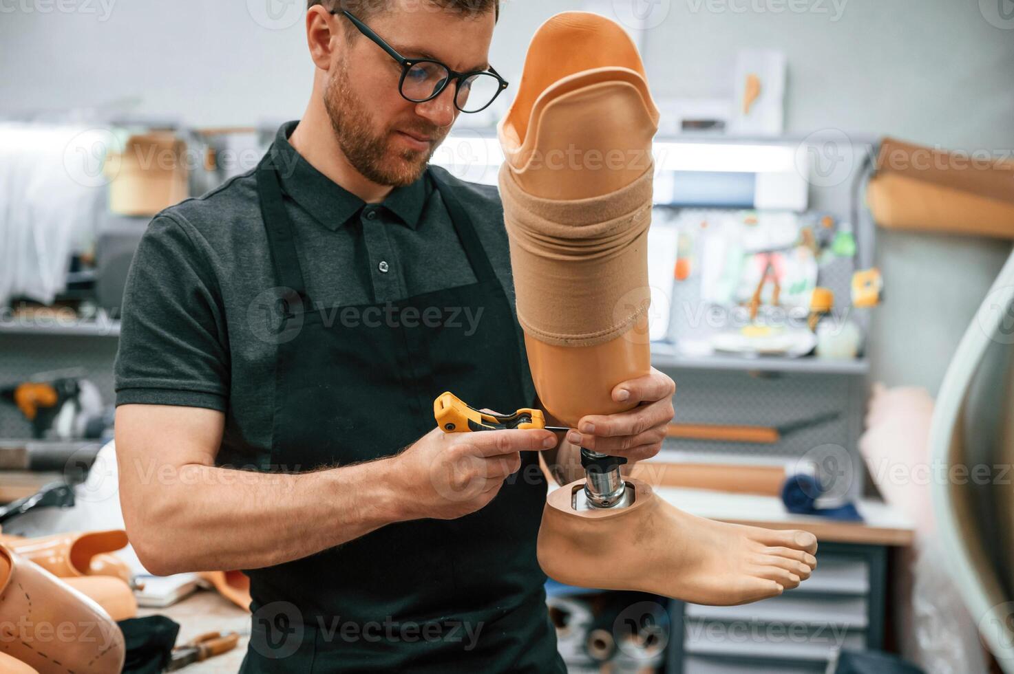 Tightening the, screws. ,Technician working with prosthesis in modern laboratory photo